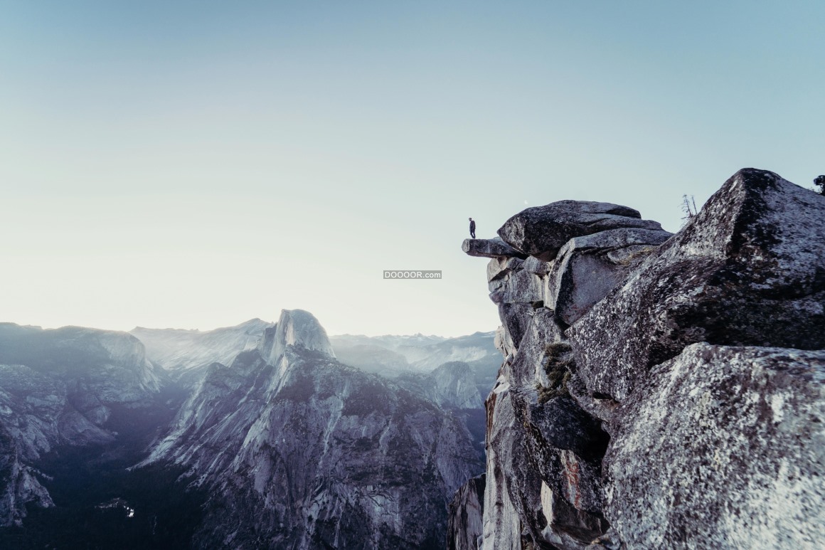 高山摄影素材一个人站在高高的石头山山顶欣赏着壮丽的自然世界
