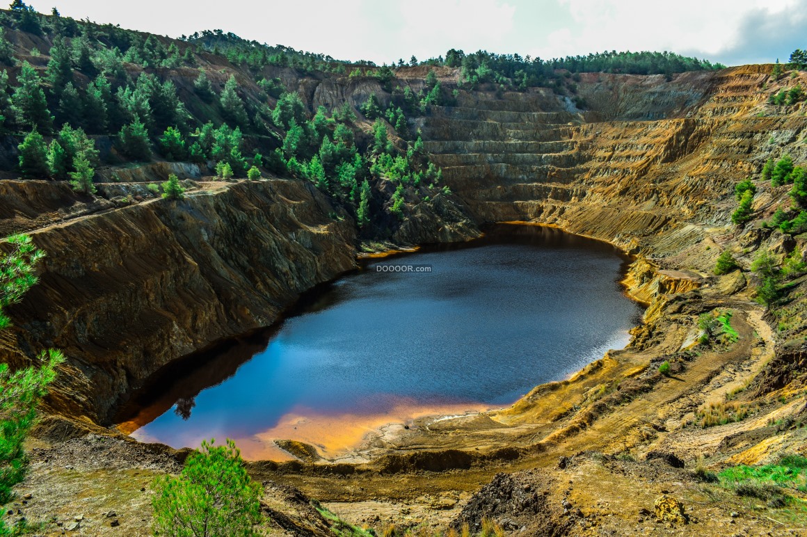 自然风景素材设计人工挖掘的矿井中心形成一座严重污染的红褐色的湖泊