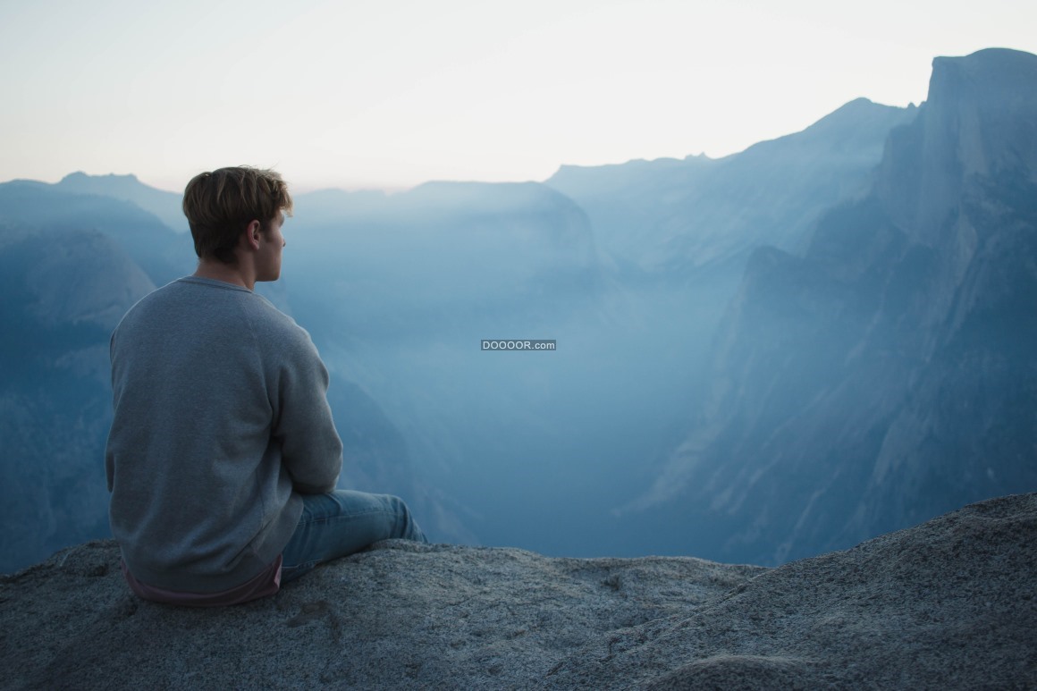 06491_年轻的男子登上高山坐在崖边看着原处沉思.jpg