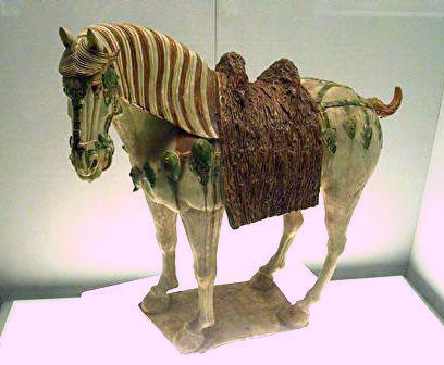 A Chinese Tang Dynasty tri-color glazed porcelain horse (ca. 700 CE), using yellow, green and white  ...