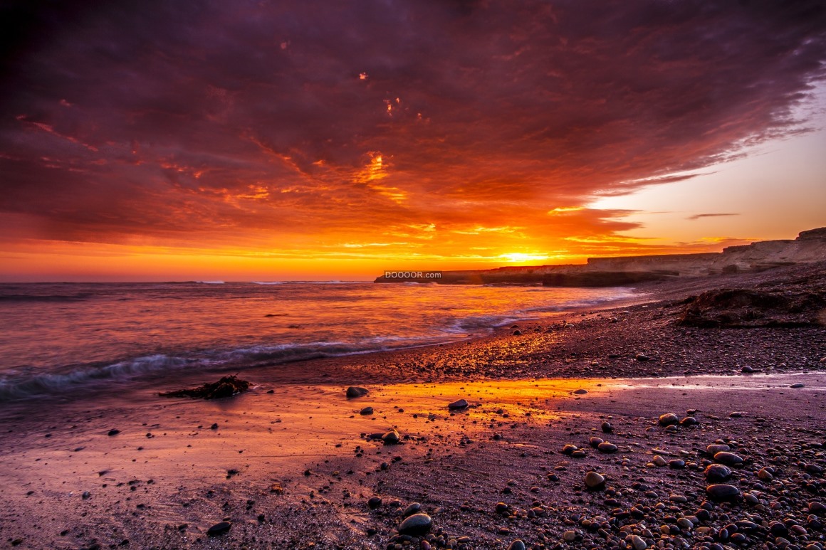 00750_夕阳的余晖将天边染红海浪一波又一波击打着海岸.jpg