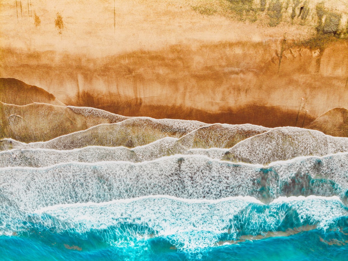01613_海岸素材摄影艺术湛蓝的海水不断地冲击着沙滩在岸边形成一层层晶莹剔透的浪花.j.jpg