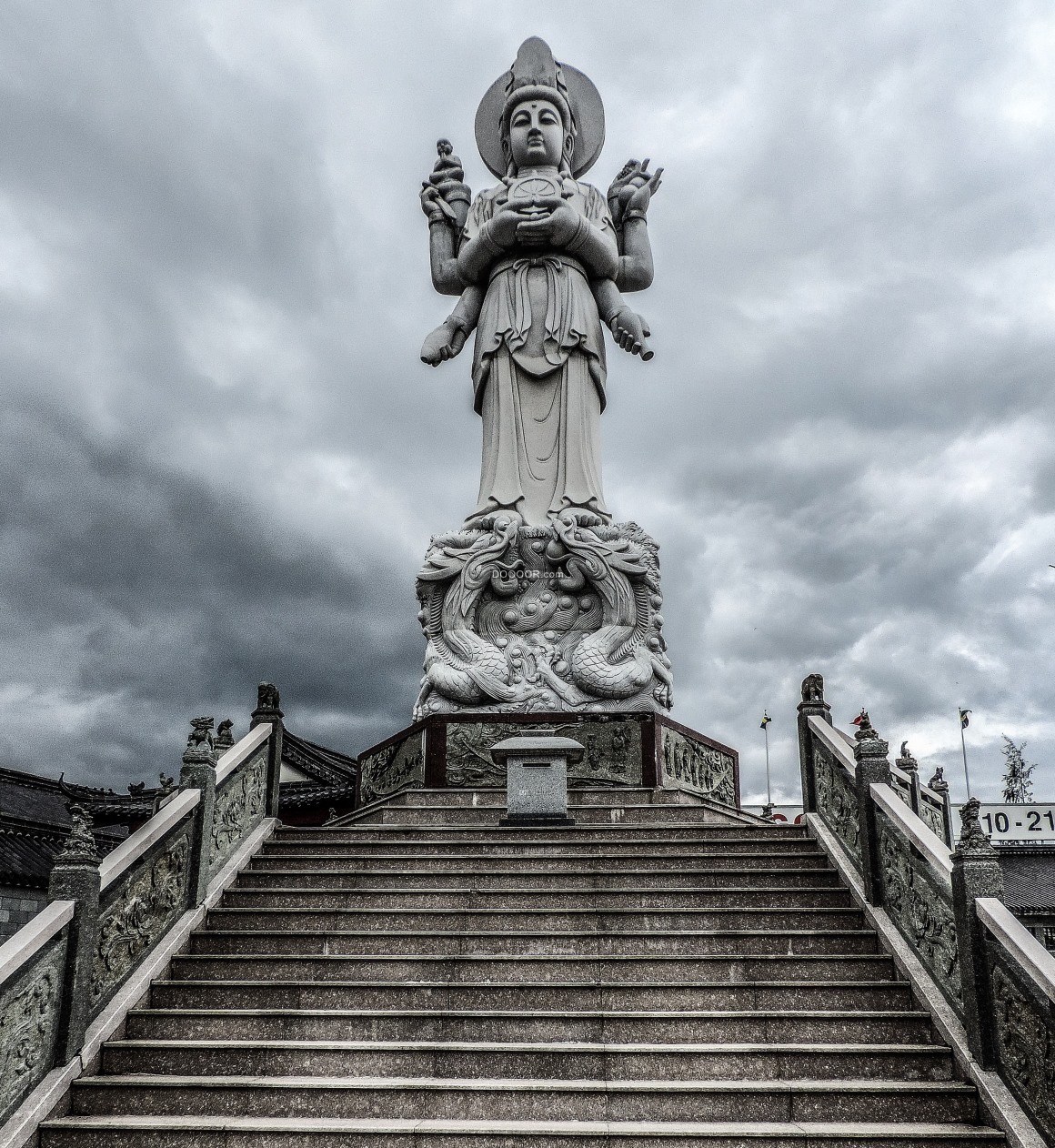 02010_地点地标宗教素材设计天空阴沉昏暗高台上矗立着一座高耸的佛教塑像面容慈祥.jpg.jpg