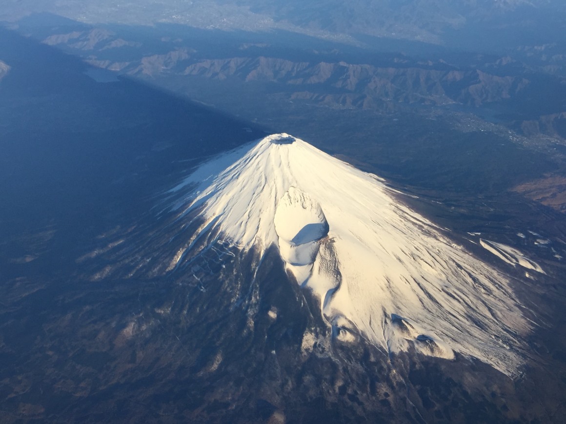 高空俯拍日本富士山山顶笼罩在皑皑的白雪之下自然风景素材设计