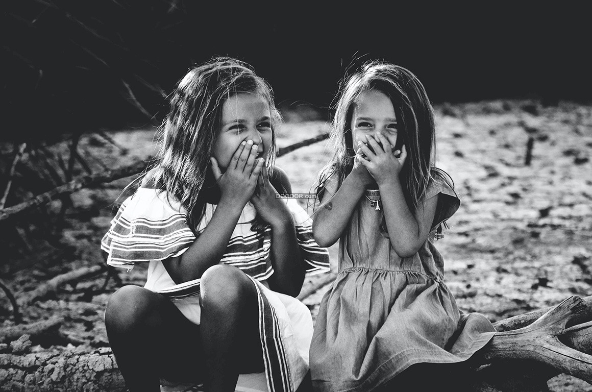 黑白风格摄影作品两个小姐妹捂着嘴微笑的表情人物素材设计