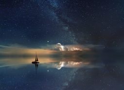 自然风景素材设计海一艘帆船行驶在风平浪静的海面上天空晴朗繁星点点海面倒映着天空与船的影子