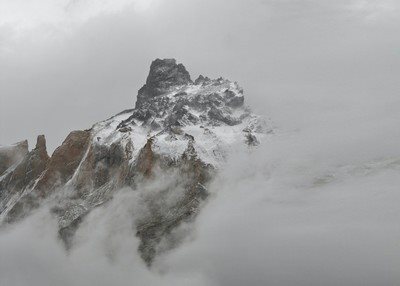 高耸的山峰覆盖着积雪洁白的云朵落在山腰翻腾