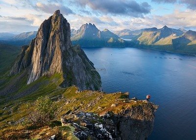 一对夫妇站在海边的悬崖上连绵起伏的高山湛蓝深邃的海水