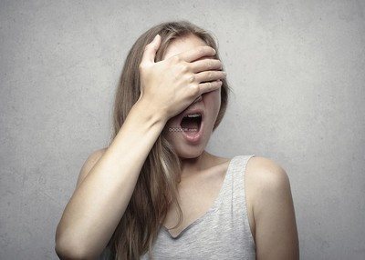 穿着灰色短T的美丽女士手捂着眼睛打着哈欠