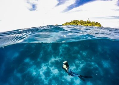 清澈透明的海洋中一位女士正在潜泳海岛度假