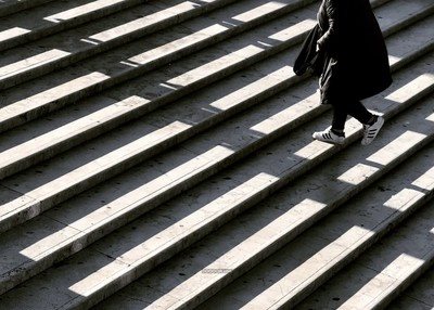 阳光照在台阶上黑色大衣白色运动鞋建筑素材